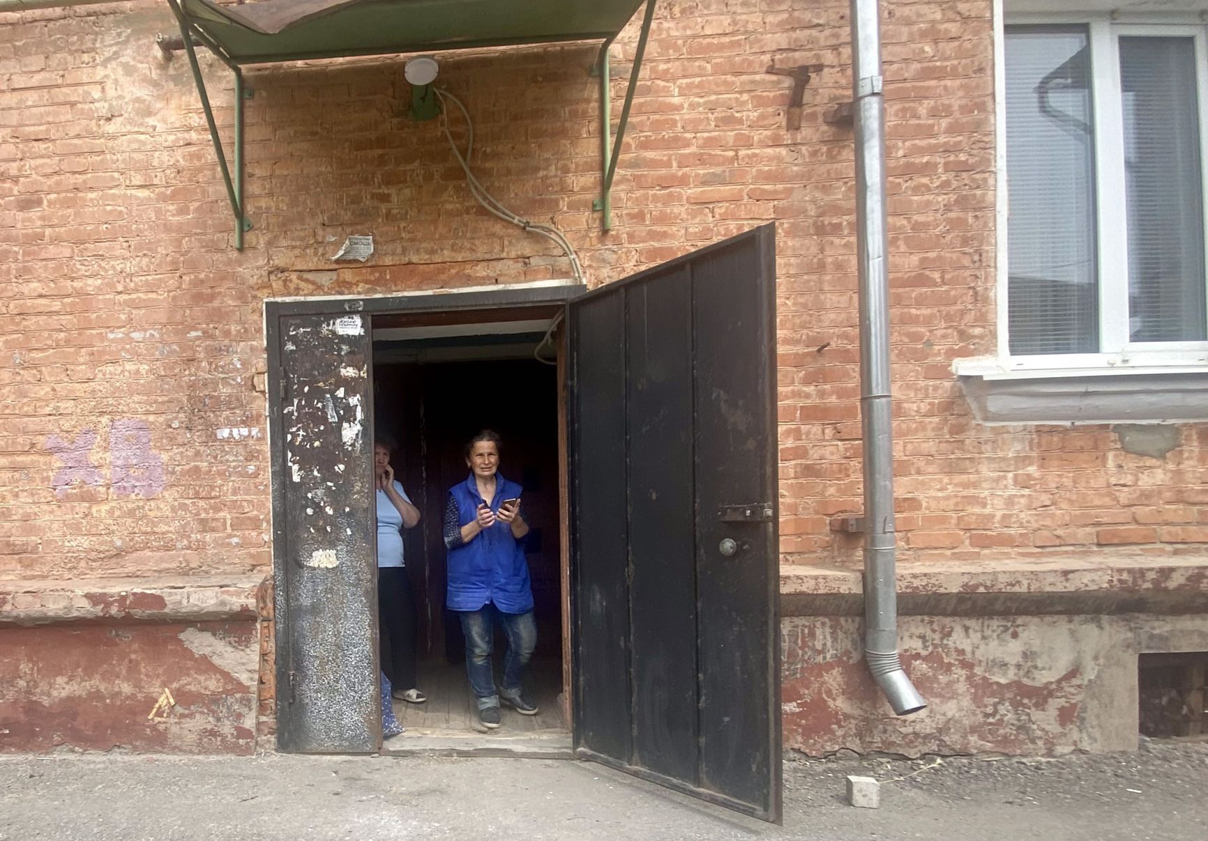 Residents take shelter in an entranceway in Shebekino