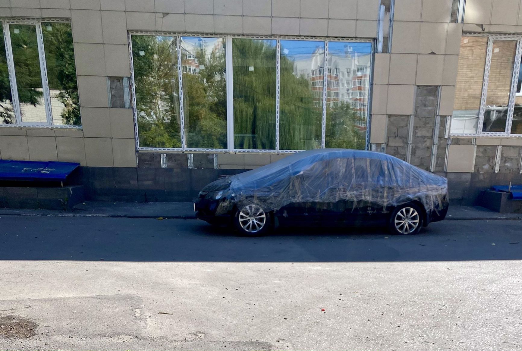 A car on Soyuznaya Street, damaged in the explosion, is still covered with a plastic sheet.